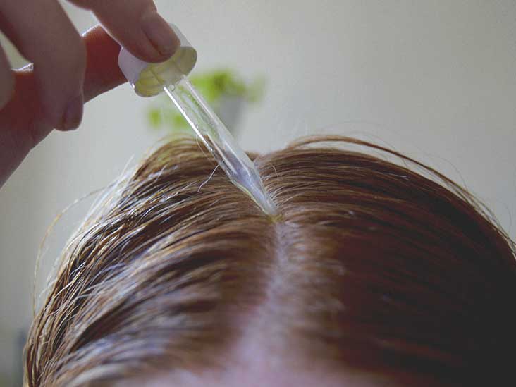 Woman Applying Hair Serum on Scalp and Hair