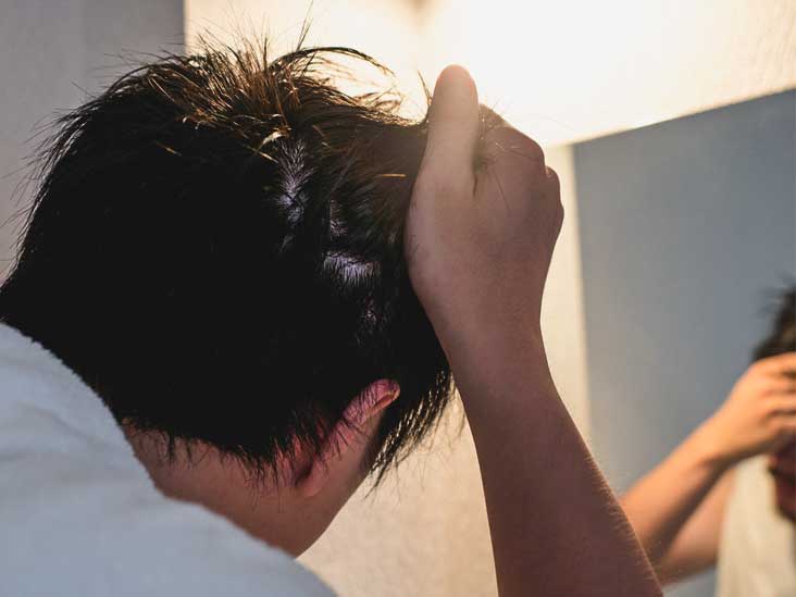 Man is drying hair and touching his hair